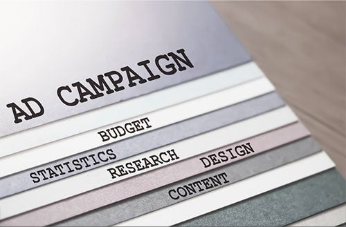 A board reading separate single words like ad campaign, budget, statistics, research, design, and content.