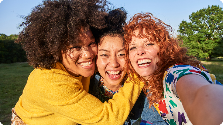 3 girls of different ethnicity smiling for a selfie photo
