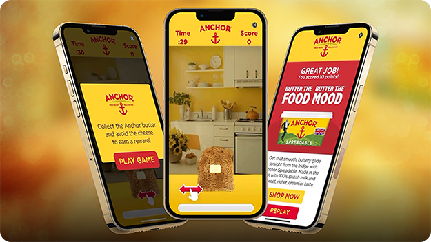 Three smartphones against a yellow background: left shows Anchor-branded game instructions, center shows gameplay with bread in a kitchen, right shows reward screen with Anchor Spreadable ad.