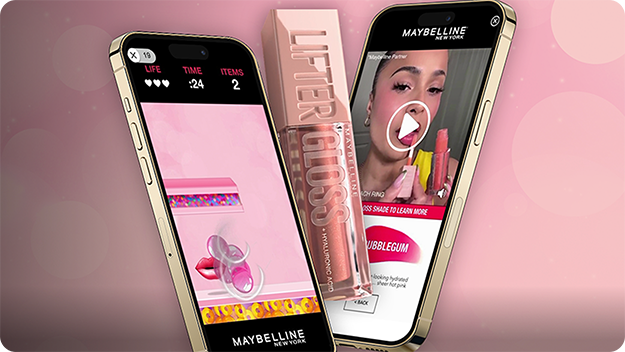 Two smartphones against a pink background with a large lip gloss tube in the center: left phone shows a pink-themed game screen with timer and items, right phone displays a Maybelline ad featuring Lifter Gloss and product details.