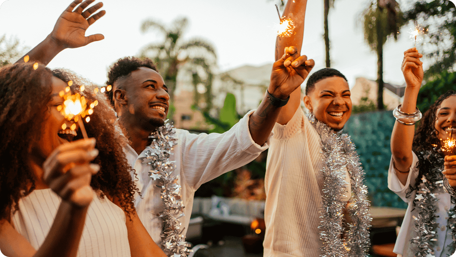 Group gathered outdoors holding sparklers during a seasonal celebration.