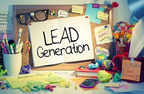 An idea board filled with sticky notes and a large sign with the message &quot;lead generation&quot; sits on top of a desk.