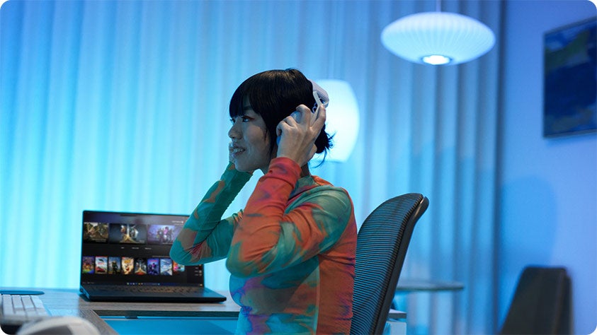 A person with headphone sitting at a desk.