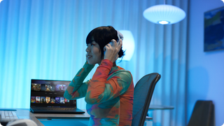 Une personne portant un casque assise à un bureau.