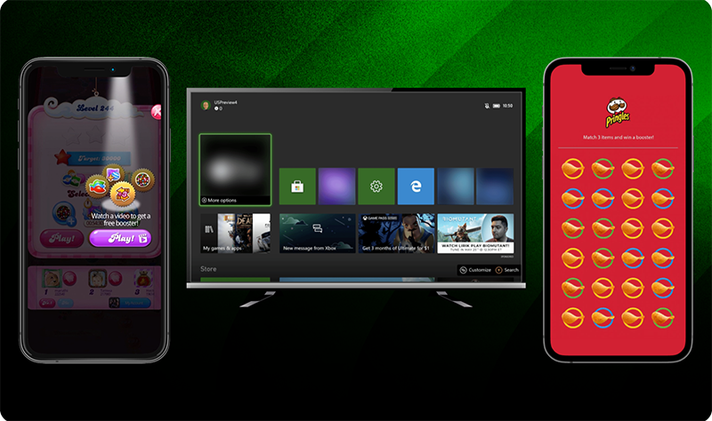 Two smartphones and a TV screen displayed against a green background: the left phone shows a candy-themed game with a prompt to watch a video for a free booster, the center TV shows an Xbox dashboard with various tiles, and the right phone shows a red screen with a branded matching game featuring multiple chip icons.