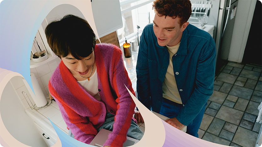 Dos personas en una cocina trabajando con un portátil.