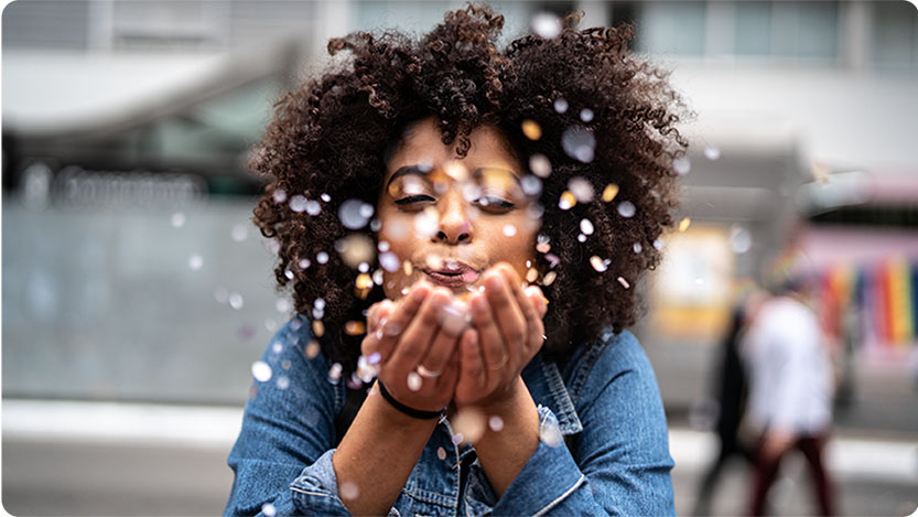 A person blowing glitter into the camera.