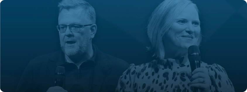 Mat Harris and Melinda Spence holding microphones onstage, shown in a blue-tinted overlay.