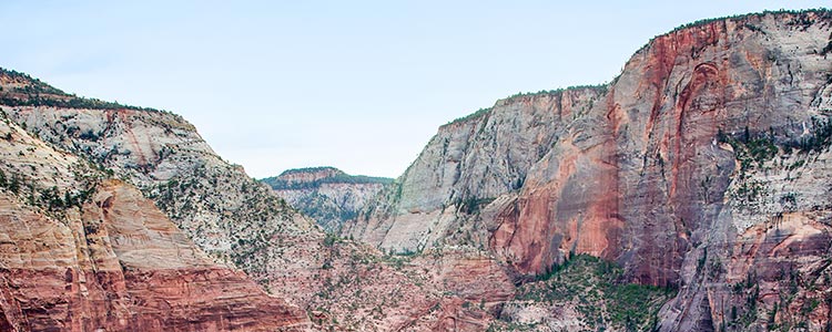 Vue des falaises rouges et abruptes d'un canyon.