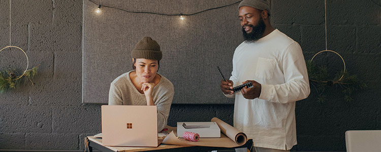 Deux personnes dans un bureau travaillent avec un ordinateur portable.