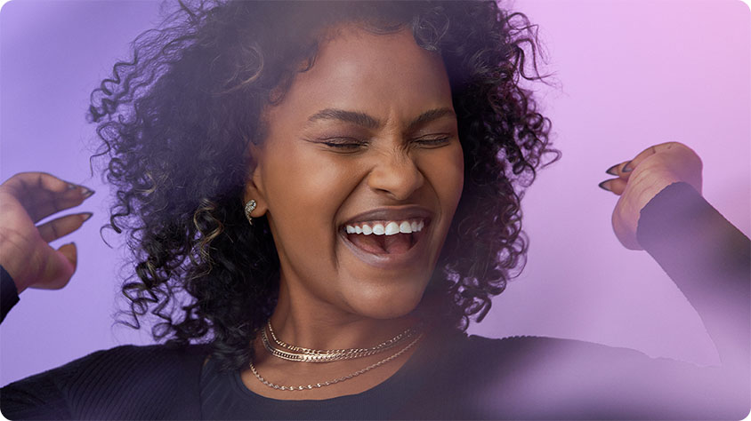 Close up image of a happy person smiling and celebrating with closed eyes.